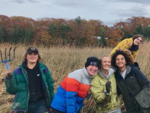 Students smile after a muddy field lab at the salt marsh
